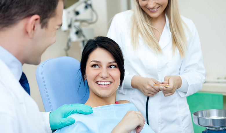 Woman at a dentist appointment speaking to dentist and hygienist