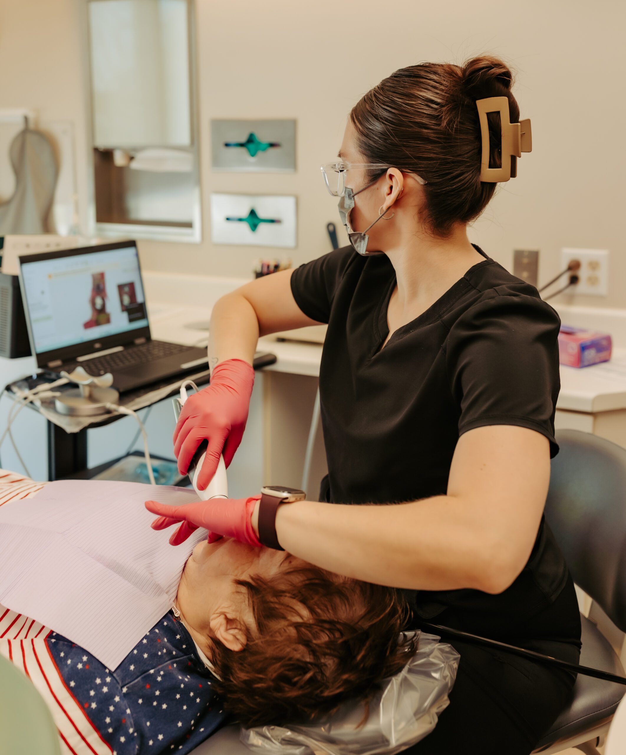 Dentist examining a boy's mouth at Dodge City Dental Care