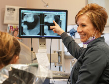 Dental hygienist showing mouth x rays to young girl at Dodge City Dental Care